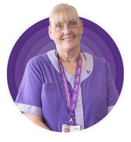 A smiling Hamill Homecare carer with a blonde fringe wears a purple uniform and branded lanyard, framed by layered purple circles.